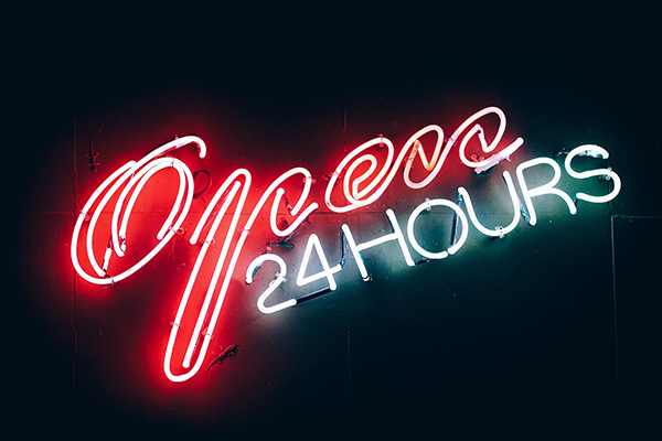 NEon light in red and white, reads 'Open 24 hours'